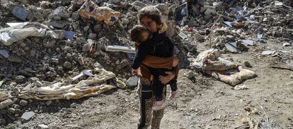 Children walk among the rubble of damaged buildings following heavy fighting between government troops and Kurdish fighters in the Kurdish town of Cizre in southeastern Turkey, which lies near the border with Syria and Iraq, on March 2, 2016. - Sputnik Afrique