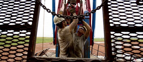 In this Tuesday, July 26, 2011 file photo, Austin Mitchell, left, and Ryan Lehto, work on an oil derrick outside of Williston, N.D. With what many are calling the largest oil boom in recent North American history, temporary housing for the huge influx of workers, known as man camps, now dot the sparse North Dakota landscape. - Sputnik Afrique