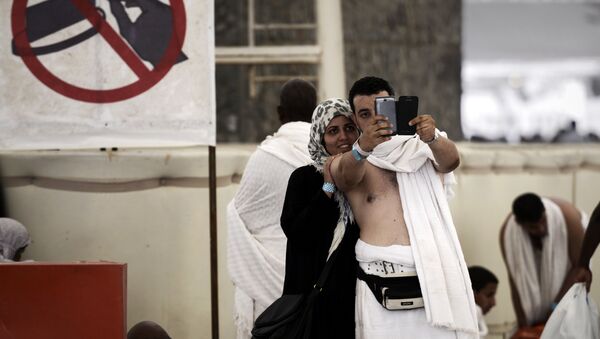 Muslim pilgrims pose for a selfie during the Jamarat ritual, the stoning of Satan, in Mina near the holy city of Mecca, on October 4, 2014. - Sputnik Afrique
