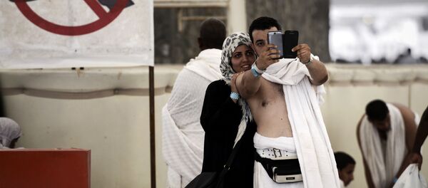 Muslim pilgrims pose for a selfie during the Jamarat ritual, the stoning of Satan, in Mina near the holy city of Mecca, on October 4, 2014. - Sputnik Afrique
