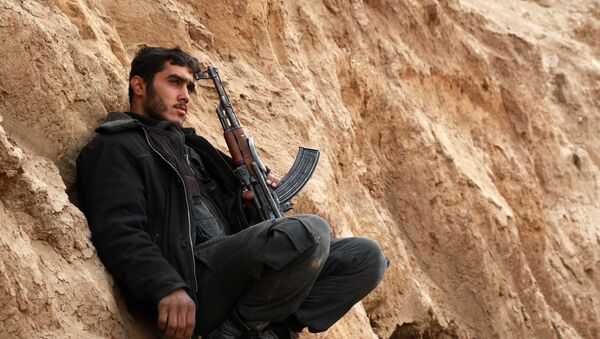 A rebel fighter, reportedly belonging to the Faylaq al-Rahman brigade, holds a position during an operation in the area of Marj al-Sultan's military airport, three days after it was recaptured by the Syrian troops, on December 17, 2015 in the rebel-held region of Eastern Ghouta, on the outskirts of the Syrian capital Damascus. Syrian troops recaptured a military airport and nearby town east of Damascus, more than three years after they were overrun by rebel groups, a military source said on December 14, 2015. - Sputnik Afrique
