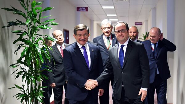 French President Francois Hollande (R) welcomes Turkish Prime Minister Ahmet Davutoglu (L) prior their meeting on the second day of a European Union summit to discuss the ongoing migrant crisis, in Brussels, on March 18, 2016. - Sputnik Afrique