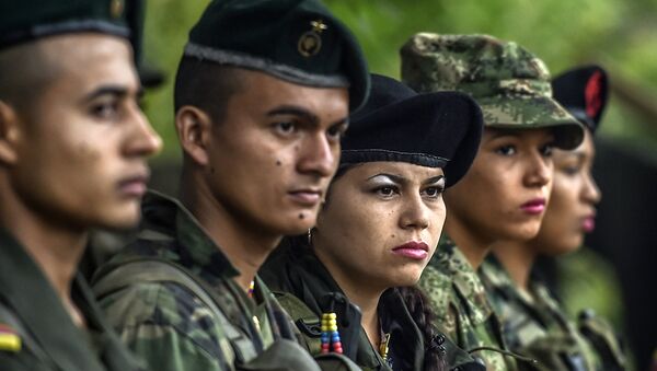 Manuela (C) and other members of the Revolutionary Armed Forces of Colombia (FARC) stand firm during a ceremony at a camp in the Colombian mountains on February 18, 2016. - Sputnik Afrique