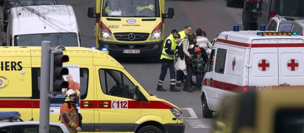 A woman is evacuated by emergency services after a explosion in a main metro station in Brussels on Tuesday, March 22, 2016 - Sputnik Afrique