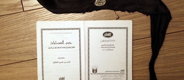 Ouvrage intitulé Moyens de lutte idéale contre le régime criminel d'Assad et un bandeau de kamikaze - Sputnik Afrique