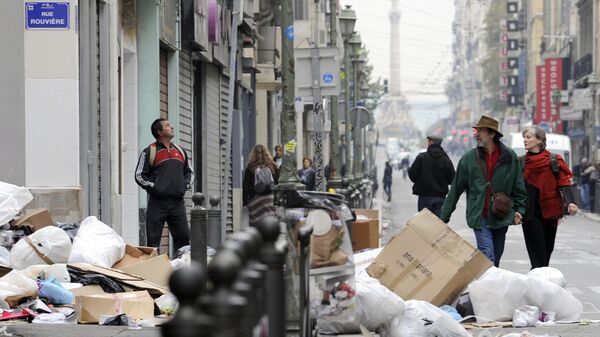 People walk by garbage piled on October 24, 2010 in a street of Marseille, as a result of a strike by rubish collectors since October 12 to protest against French President's bid to raise the retirement age. The pensions reform bill was approved by the Senate on October 22, and the text will be reconciled October 25 with the draft passed earlier by the lower house. However, strikes have continued across the industry. - Sputnik Afrique