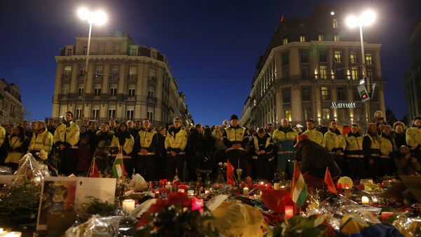 Les sauveteurs en gilets jaunes se rassemblent à la place de la Bourse pour rendre hommage aux victimes des attentats de mardi à Bruxelles, Belgique, le 25 Mars, 2016. - Sputnik Afrique
