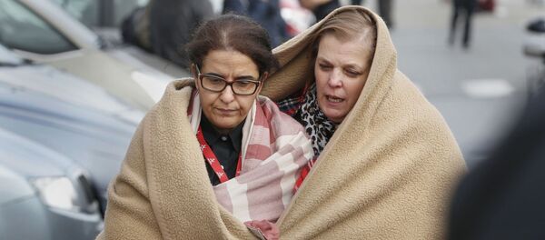 People wrapped in blankets leave the scene of explosions at Zaventem airport near Brussels, Belgium, March 22, 2016 - Sputnik Afrique