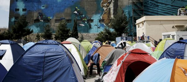 An Afghan migrant sits among tents at a makeshift camp for refugees and migrants at the port of Piraeus, near Athens, Greece March 24, 2016. An Afghan migrant sits among tents at a makeshift camp for refugees and migrants at the port of Piraeus, near Athens, Greece March 24, 2016. - Sputnik Afrique