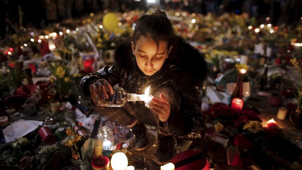 A girl lights candles as people pay tribute to the victims of Tuesday's bomb attacks, at the Place de la Bourse in Brussels, Belgium, March 26, 2016. - Sputnik Afrique