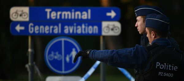 Police officers stand guard at the Brussels Airport in Zaventem following twin blasts on March 22, 2016. - Sputnik Afrique
