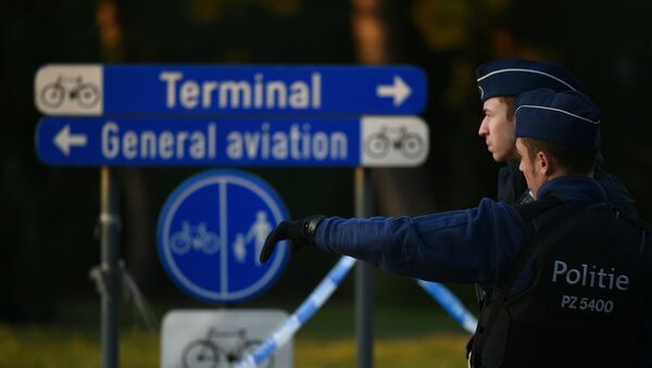 Police officers stand guard at the Brussels Airport in Zaventem following twin blasts on March 22, 2016. - Sputnik Afrique