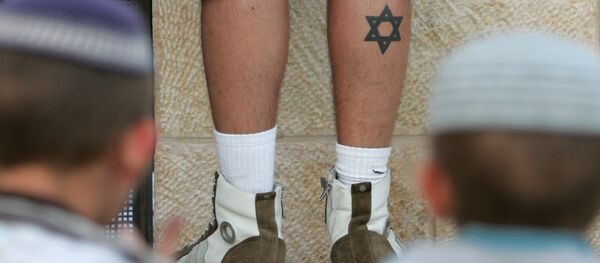 Two Orthodox Jewish boys look at a David star tattoo on the leg of a fellow worshipper at the Wailing Wall in the heart of Jerusalem's Old City during the annual commemoration of the destruction of the first and second Jewish temples on August 10, 2008. - Sputnik Afrique