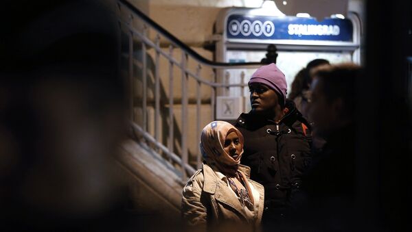 A woman and a man stand as they are evacuated by police officers and gendarmes from a makeshift camp under the Stalingrad railway station in Paris on March 30, 2016 - Sputnik Afrique