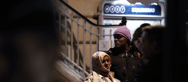 A woman and a man stand as they are evacuated by police officers and gendarmes from a makeshift camp under the Stalingrad railway station in Paris on March 30, 2016 - Sputnik Afrique