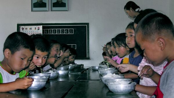 In this picture taken 18 July 2005, North Korean children eat their lunch at a government-run kindergarten in Taedong county, North Korea. - Sputnik Afrique