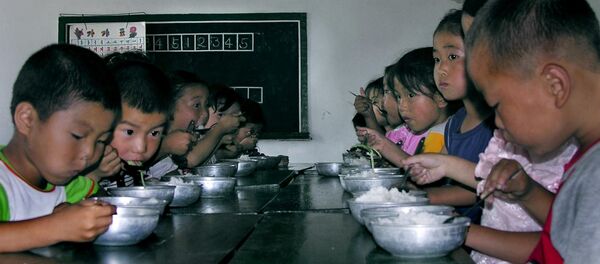 In this picture taken 18 July 2005, North Korean children eat their lunch at a government-run kindergarten in Taedong county, North Korea. - Sputnik Afrique