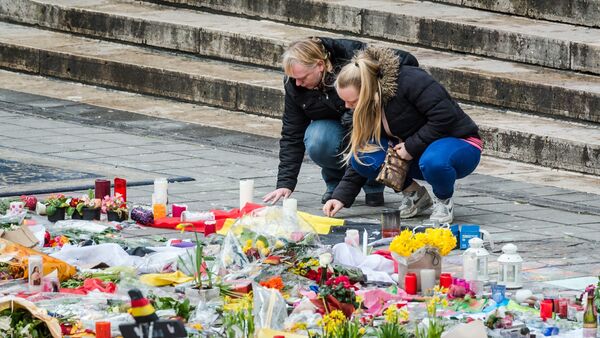 Two women read a solidarity message at floral tributes at a memorial site at the Place de la Bourse in Brussels, Sunday, March 27, 2016. - Sputnik Afrique