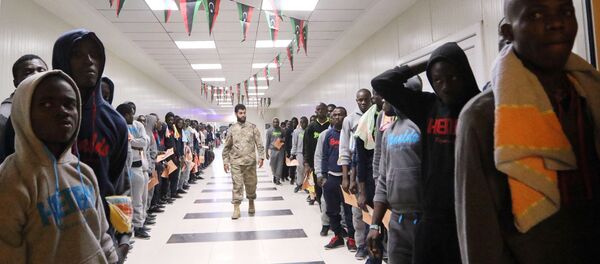 Migrants wait in line at the Metiga Airport in the Libyan capital Tripoli on March 11, 2016 ahead of their repatriation to their countries of origin by the Libyan authorities. Migrants wait in line at the Metiga Airport in the Libyan capital Tripoli on March 11, 2016 ahead of their repatriation to their countries of origin by the Libyan authorities. - Sputnik Afrique