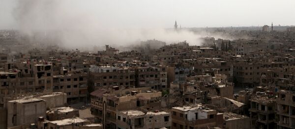 Smoke rises from what activists said was an airstrike by forces loyal to Syria's President Bashar al-Assad on the town of Douma, eastern Ghouta of Damascus September 16, 2015. - Sputnik Afrique