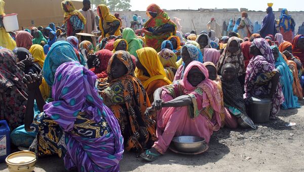 Internally Displaced Persons (IDP) mostly women and children sit waiting to be served with food at Dikwa Camp, in Borno State in north-eastern Nigeria, on February 2, 2016. - Sputnik Afrique
