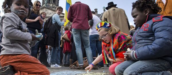 Children draw the Ukraine flag on Dam Square as demonstrators for a YES vote for Wednesday's upcoming EU-Ukraine referendum gathered in Amsterdam, Netherlands, Sunday, April 3, 2016. - Sputnik Afrique