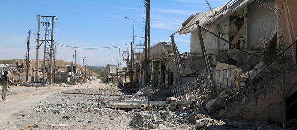 A man walks near damaged houses after Syrian rebels and the al Qaeda-affiliated Nusra Front took control of al-'Iss town, in Aleppo countryside, Syria April 2, 2016. - Sputnik Afrique