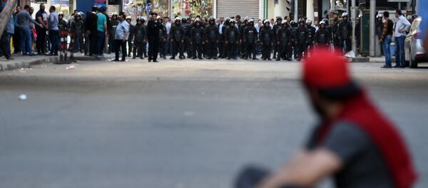 An Egyptian protester sits on the ground in front of riot policemen during a demonstration against a controversial deal to hand two islands in the Red Sea to Saudi Arabia on April 15, 2016 outside the Journalists' Syndicate in central Cairo. - Sputnik Afrique