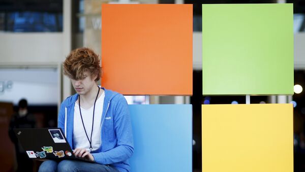 An attendee works next to the Microsoft logo during the Microsoft Build 2016 Developers Conference in San Francisco, California March 30, 2016. REUTERS/Beck Diefenbach - Sputnik Afrique