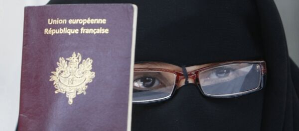 FILE - This May 18, 2010 file photo shows a woman, who gave her name as Najat, holding her passport during a press conference in Montreuil, east of Paris. FILE - This May 18, 2010 file photo shows a woman, who gave her name as Najat, holding her passport during a press conference in Montreuil, east of Paris. - Sputnik Afrique