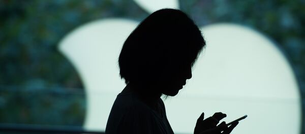 A customer uses her new smartphone during the release of the iPhone 6s at an Apple store in Shanghai on September 25, 2015. - Sputnik Afrique