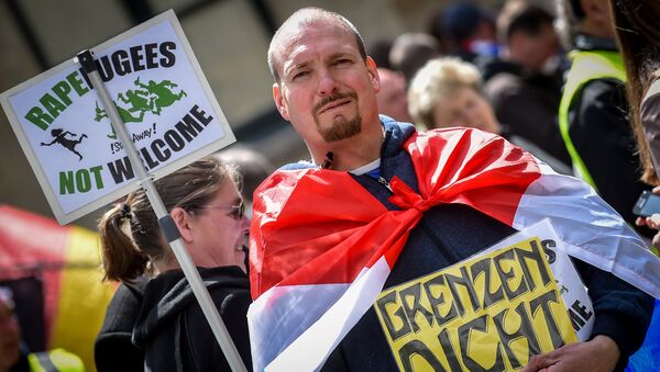 A demonstrator holds a placard reading rapefugees not welcome during a demonstration against Islamic terror organised by far-right movement Pegida Vlaanderen, on April 23, 2016, in Antwerp - Sputnik Afrique