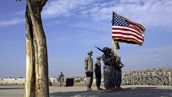 US soldiers carry an American flag as they unfurl their division's new colors during a handover ceremony from the 4th Infantry Division to the 1st Cavalry Division at a US military base in Baghdad, 15 November 2006. - Sputnik Afrique