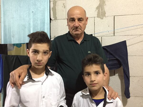 Cet homme s’occupe de ces deux garçons qui ont été blessés au cours d’une attaque des djihadistes - Sputnik Afrique