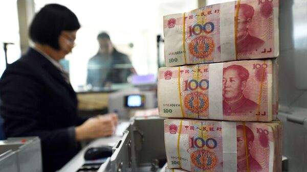 Un employé qui compte  des billets de banque dans une banque de 100 yuans (14 euros) à Lianyungang, dans l'Est de la province du Jiangsu le 7 Janvier 2016 - Sputnik Afrique