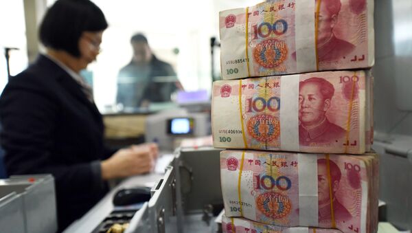 Un employé qui compte  des billets de banque dans une banque de 100 yuans (14 euros) à Lianyungang, dans l'Est de la province du Jiangsu le 7 Janvier 2016 - Sputnik Afrique