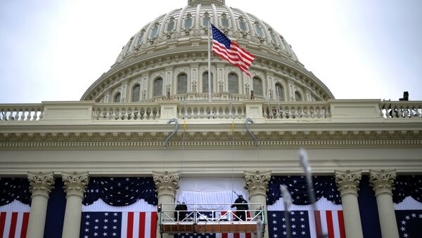Two workers adjust the US flag on the Capitol as preparations continue for the second inauguration of US President Barack Obama in Washington, DC, on January 17, 2013. - Sputnik Afrique