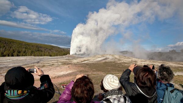 Tourists photograph Old Faithful erupting at Yellowstone National Park in Montana. - Sputnik Afrique