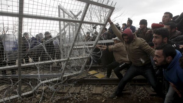 Stranded refugees and migrants try to bring down part of the border fence during a protest at the Greek-Macedonian border, near the Greek village of Idomeni, February 29, 2016 - Sputnik Afrique