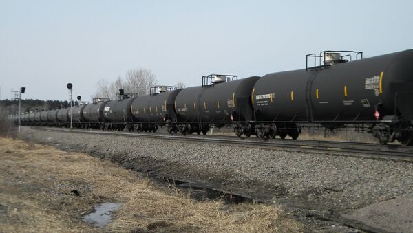 FILE - In this April 15, 2014 file photo, an oil-tank train with crude oil from the Bakken shale fields of North Dakota travels near Staples, Minn. The University of Minnesota releases a new study on financial losses for farmers due to rail delays in shipping agriculture commodities, blaming the vast quantities of oil leaving North Dakota for squeezing out other rail traffic. - Sputnik Afrique