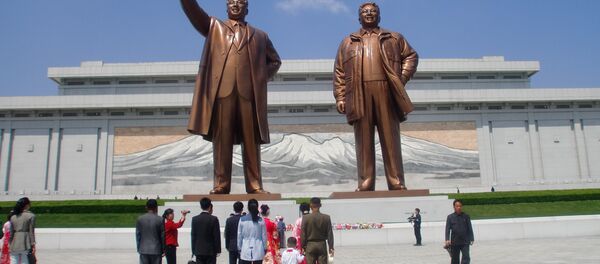 Des jeunes mariés et leurs proches devant le Grand Monument Mansudae à Pyongyang - Sputnik Afrique