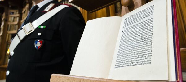 A Carabinieri policeman stands, Wednesday, May 18, 2016, next to a book, bottom, reproducing a letter written by Christopher Columbus in 1493 about his discovery of the New World that had been replaced at Florence's Riccardiana library with a forgery, at top, that no one noticed until a few years ago, during a press conference in Rome. A Carabinieri policeman stands, Wednesday, May 18, 2016, next to a book, bottom, reproducing a letter written by Christopher Columbus in 1493 about his discovery of the New World that had been replaced at Florence's Riccardiana library with a forgery, at top, that no one noticed until a few years ago, during a press conference in Rome. - Sputnik Afrique