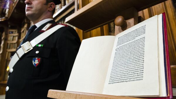 A Carabinieri policeman stands, Wednesday, May 18, 2016, next to a book, bottom, reproducing a letter written by Christopher Columbus in 1493 about his discovery of the New World that had been replaced at Florence's Riccardiana library with a forgery, at top, that no one noticed until a few years ago, during a press conference in Rome. - Sputnik Afrique