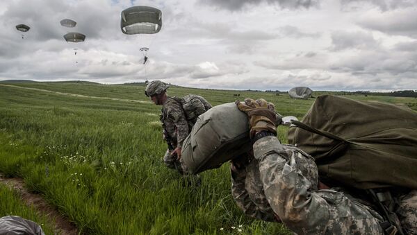 US para-troopers of the Army's 4th 25 Infantry Brigade Combat Team (Airborne), part of the NATO-led peacekeeping mission in Kosovo (KFOR) jump with parachute during a military drill near the village of Ramjan on May 27, 2015 - Sputnik Afrique