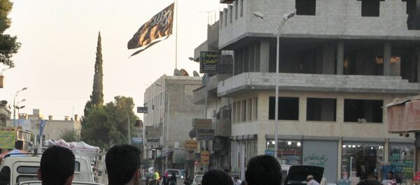 A group of men look at a large black Jihadist flag with Islamic writing on it proclaiming in Arabic that There is no God but God and Mohammed is the prophet of God, as they look over towards a building in the northern rebel-held Syrian city of Raqqa on September 28, 2013. - Sputnik Afrique
