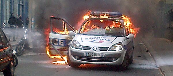 This picture taken with a mobile phone shows a police car burning after being set on fire during an unauthorized counter-demonstration against police violence on May 18, 2016 in Paris, as Police across France demonstrate today against the anti-cop hatred they say they have endured during a wave of anti-government protests since early March. - Sputnik Afrique