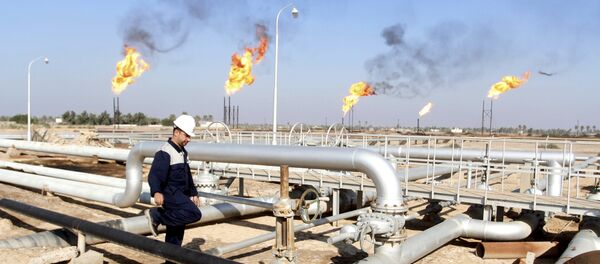 Un ouvrier se promène au champ pétrolier de Nahr Bin Umar, au nord de Bassorah, en Irak le 21 Décembre 2015 - Sputnik Afrique