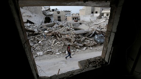 A man walks past damaged buildings in the rebel-controlled area of Maaret al-Numan town in Idlib province, Syria, May 15, 2016 - Sputnik Afrique