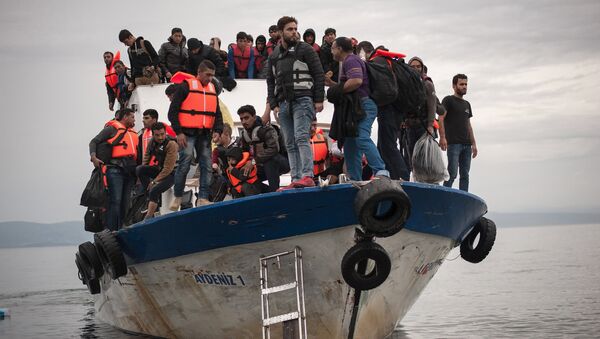 Migrants and refugees are seen aboard a Turkish fishing boat as they arrive on the Greek island of Lesbos after crossing a part of the Aegean Sea from theTurkish coast to Lesbos October 11, 2015 - Sputnik Afrique