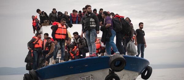 Migrants and refugees are seen aboard a Turkish fishing boat as they arrive on the Greek island of Lesbos after crossing a part of the Aegean Sea from theTurkish coast to Lesbos October 11, 2015 - Sputnik Afrique
